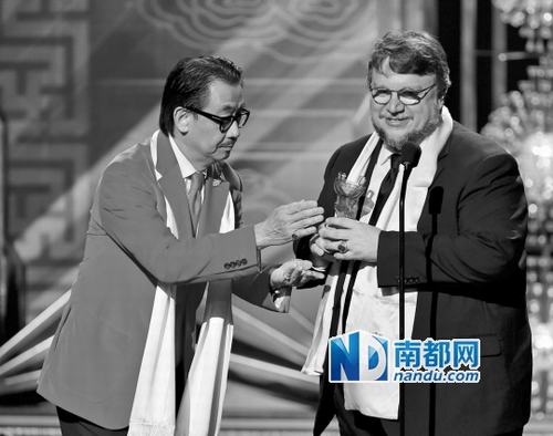 华裔演员陈乔治为《环太平洋》导演吉尔莫·德尔·托罗颁全球最佳导演奖。